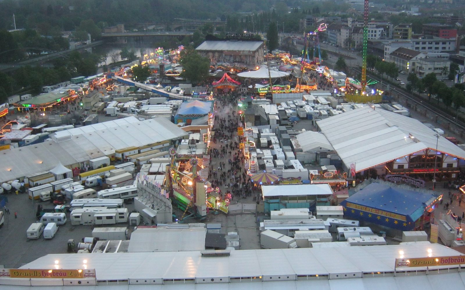 Stuttgarter Frühlingsfest auf dem Cannstatter Wasen - Blick vom Riesenrad über Festzelte und Fahrgeschäfte